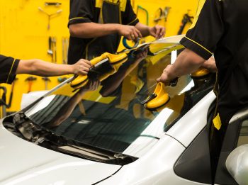 Repairman is repairing windshield of the car